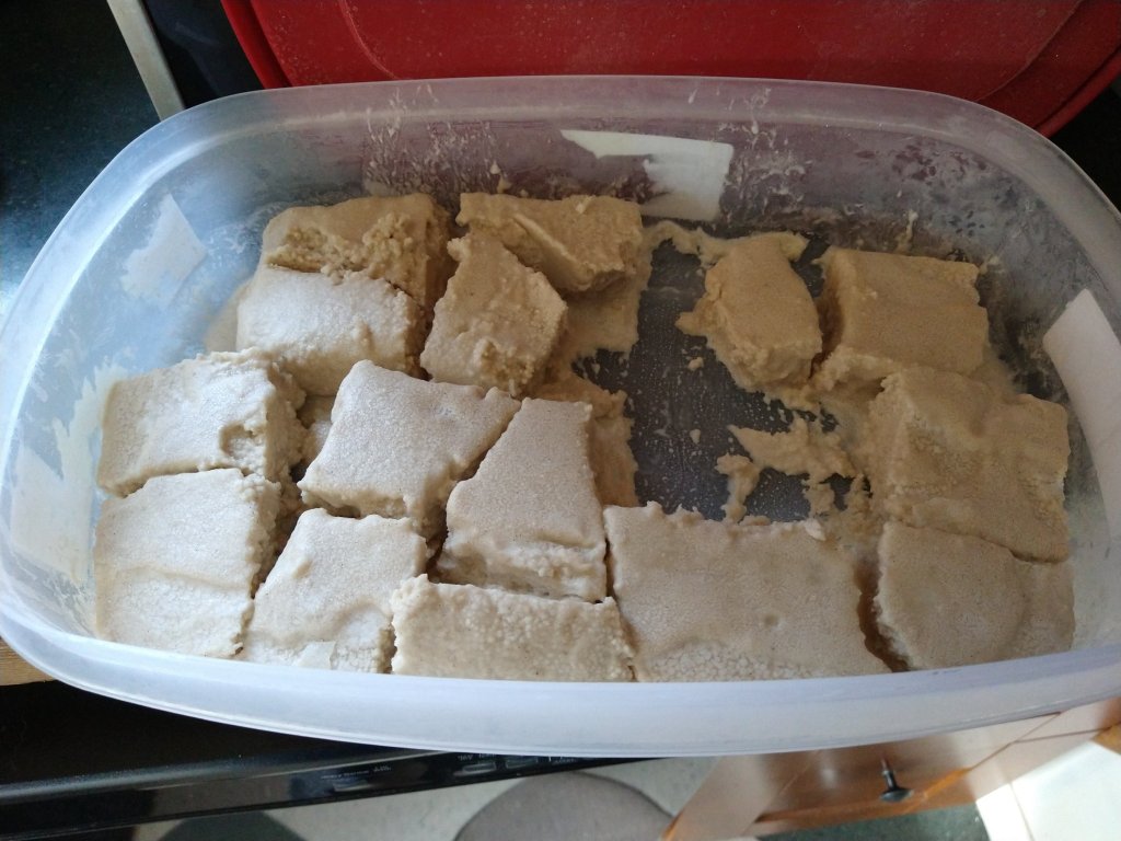 Picture of frozen banana gelato chunks in a large Rubbermaid plastic container. 